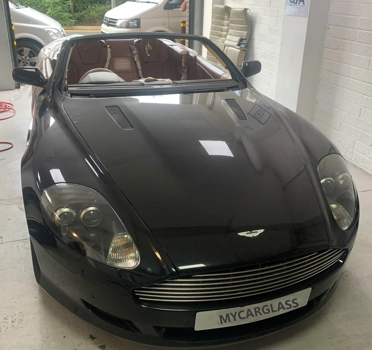Black Aston Martin DB9 front view before windscreen work.