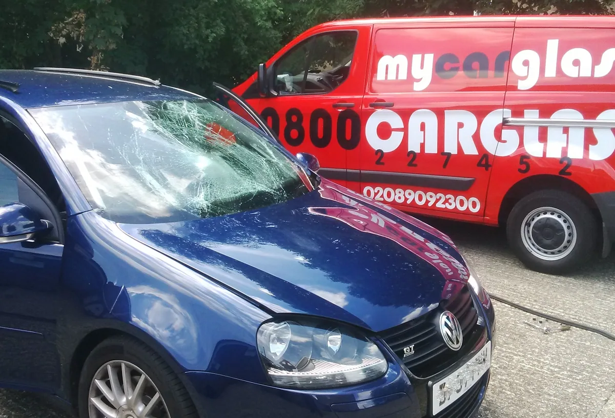 Dark blue car at the MyCarGlass workshop with branded backdrop.