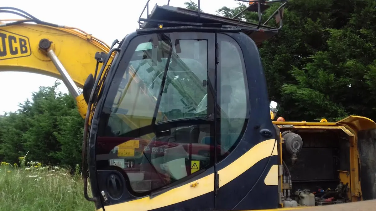 JCB JS130 excavator with new cab door glass installed.