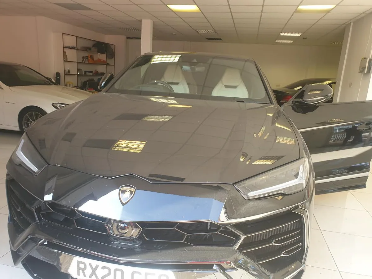 Close-up of the camera mount and rain sensor area on the Lamborghini Urus windscreen.