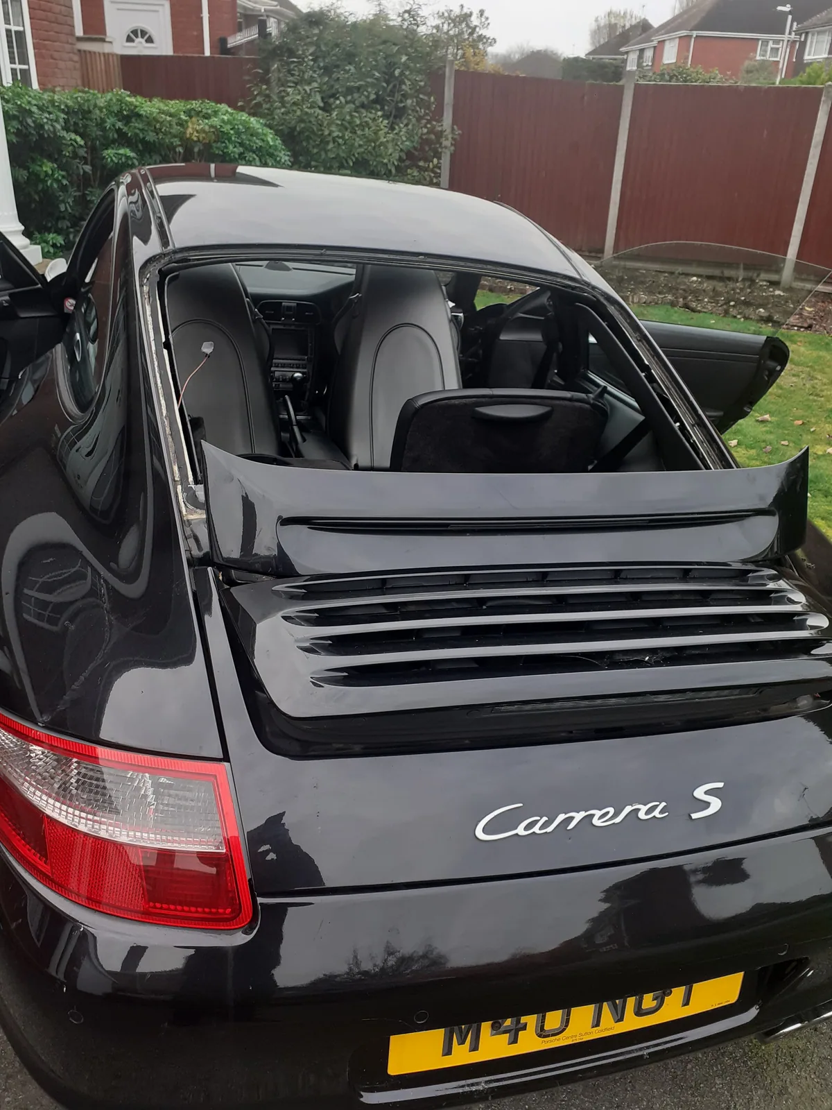 Porsche 911 with the rear window being replaced.