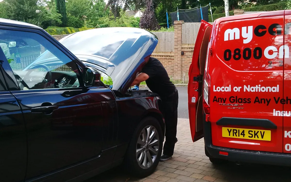 Windscreen installation with the MyCarGlass van alongside in the workshop.